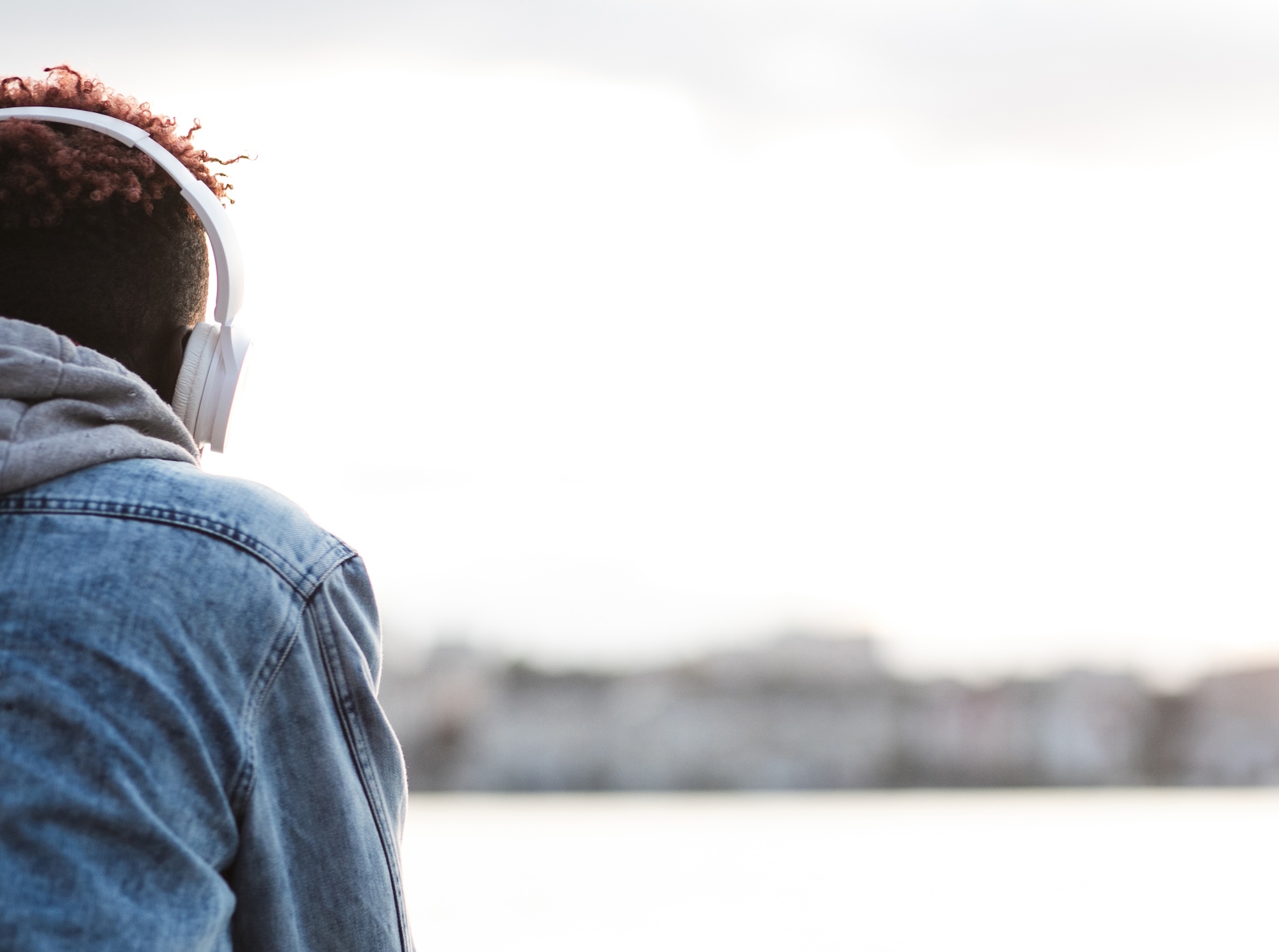 close-up-guy-with-headphones-near-lake